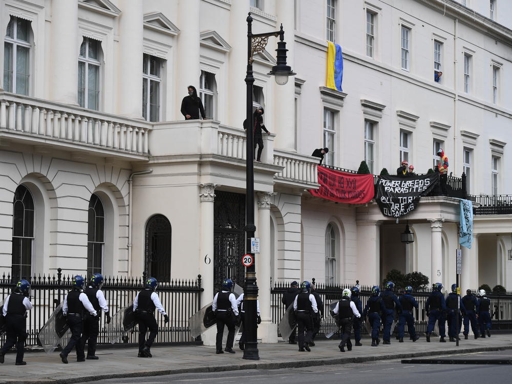 Police officers in riot gear arrive at the building reportedly belonging to Russian oligarch Oleg Deripaska on Monday in London.