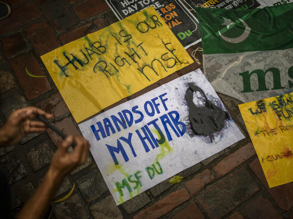 A student takes photographs of placards during a protest against banning Muslim girls from wearing the hijab in educational institutions in the southern Indian state of Karnataka, in New Delhi on Feb. 8, 2022.