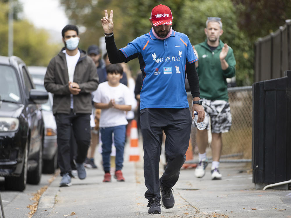 Al Noor Mosque shooting survivor Temel Atacocugu gestures as he completes his walk from Dunedin to Christchurch on the third anniversary of the shootings in Christchurch, New Zealand, on Tuesday.