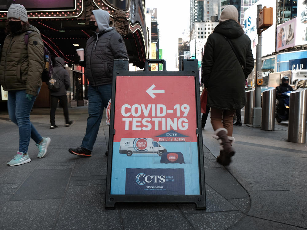 People pass a COVID-19 testing site on a Manhattan street on Jan. 21. The White House says it is running out of money to pay for coronavirus tests for people who don't have insurance.