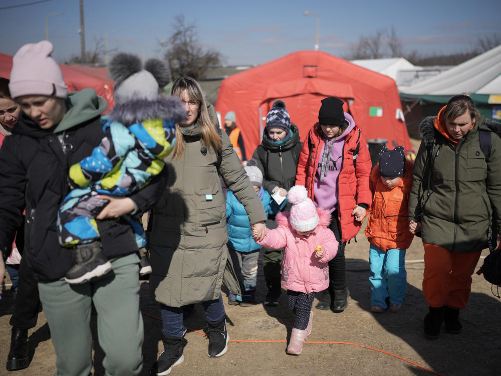 Refugees fleeing Ukraine receive food from the International Red Cross and other organizations at the Vysne Nemecke border crossing in Slovakia on Sunday.