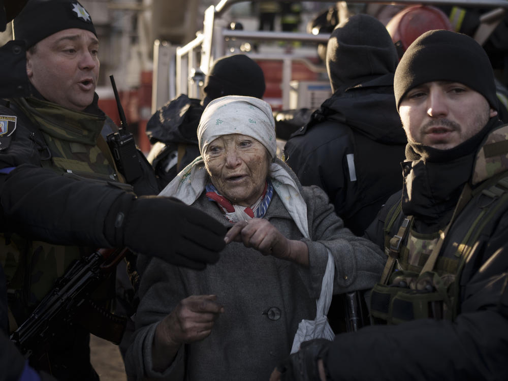 An elderly woman is helped by policemen after she was rescued by firefighters from inside her apartment after bombing in Kyiv, Ukraine, on Tuesday.
