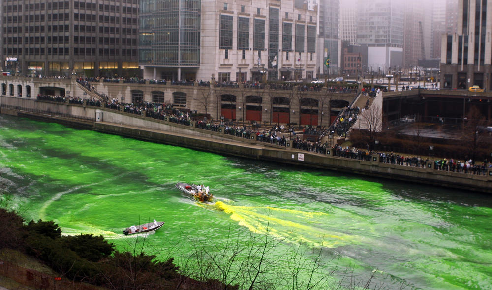 People watch as the Chicago River is dyed green (using an orange powder) on March 13, 2010, as part of the city's celebration of St. Patrick's Day.