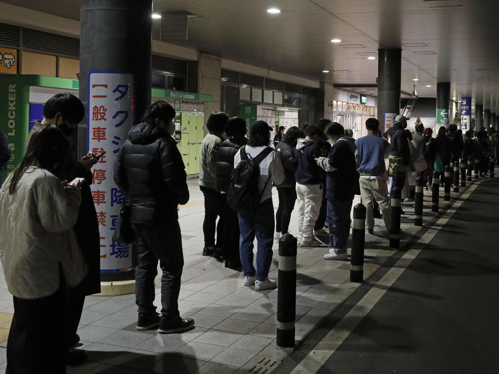 People wait in line for taxis in Sendai, Miyagi prefecture, northern Japan, early Thursday following a powerful earthquake that struck off the coast of Fukushima.