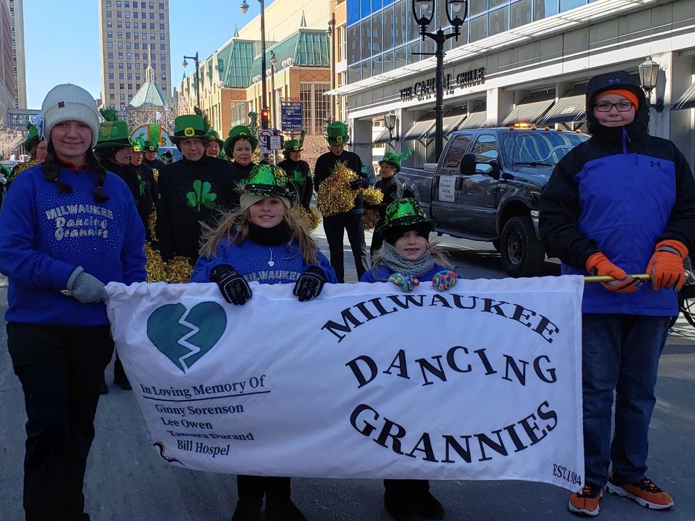 Two of Ginny Sorenson's granddaughters holding a banner honoring the fallen group members during the St. Patrick's Day parade in Milwaukee. Before Sorenson was killed, she choreographed two of the Irish routines the group danced to during the parade.