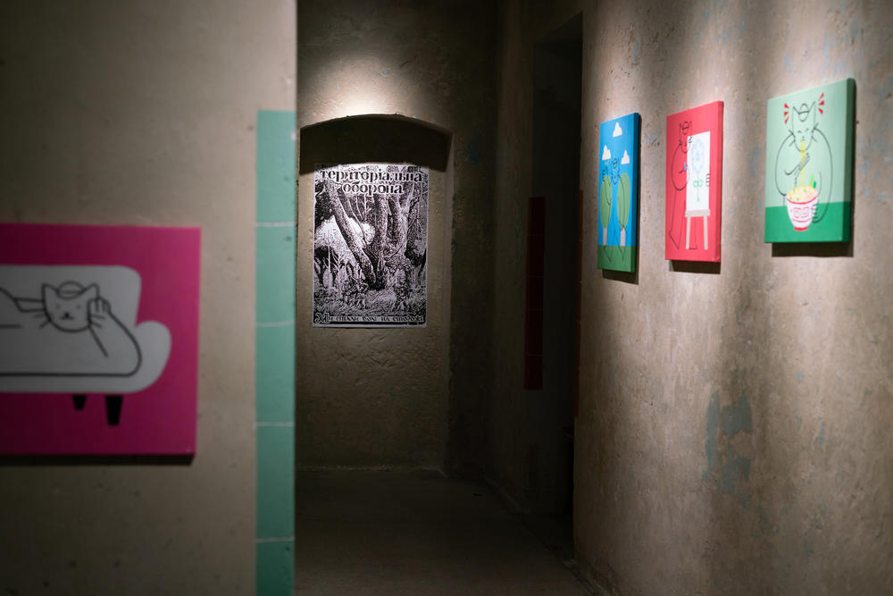 A poster for the territorial defense forces hangs in Lviv Municipal Arts Center among other artwork.