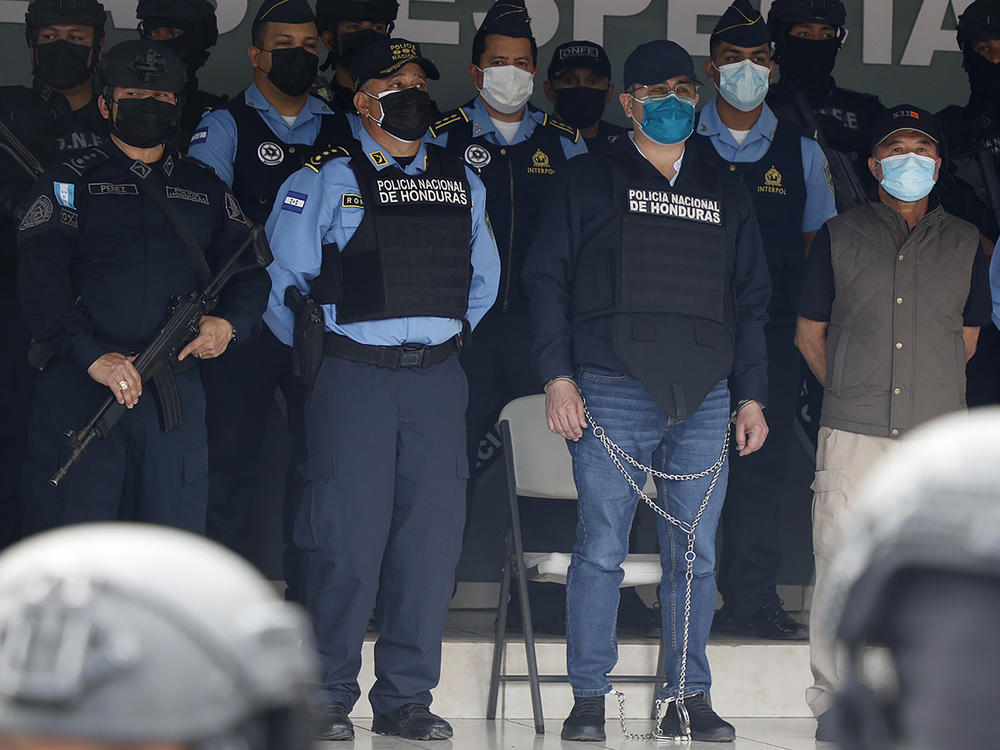 Former Honduran President Juan Orlando Hernandez, center in chains, is shown to the press at the police headquarters in Tegucigalpa, Honduras on Feb. 15, 2022.