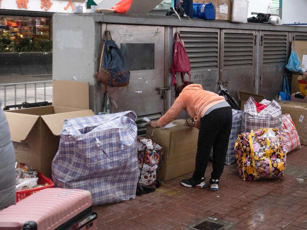 This photo taken on Feb. 20 shows a foreign worker in Hong Kong sheltering with her belongings during the city's current coronavirus surge.
