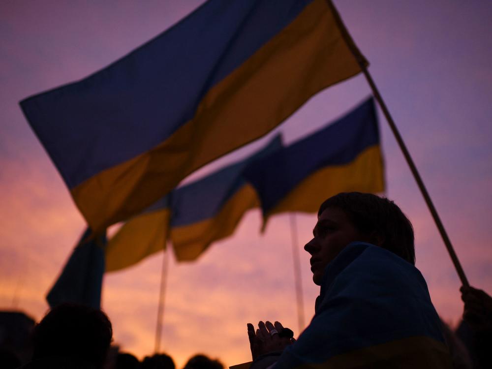 A demonstrator, holding a Ukrainian flag, participates in a demonstration called by 70 associations in support of Ukraine on the square of Paris' town hall on Thursday. It has been three weeks since Russia began its assault on Ukraine.
