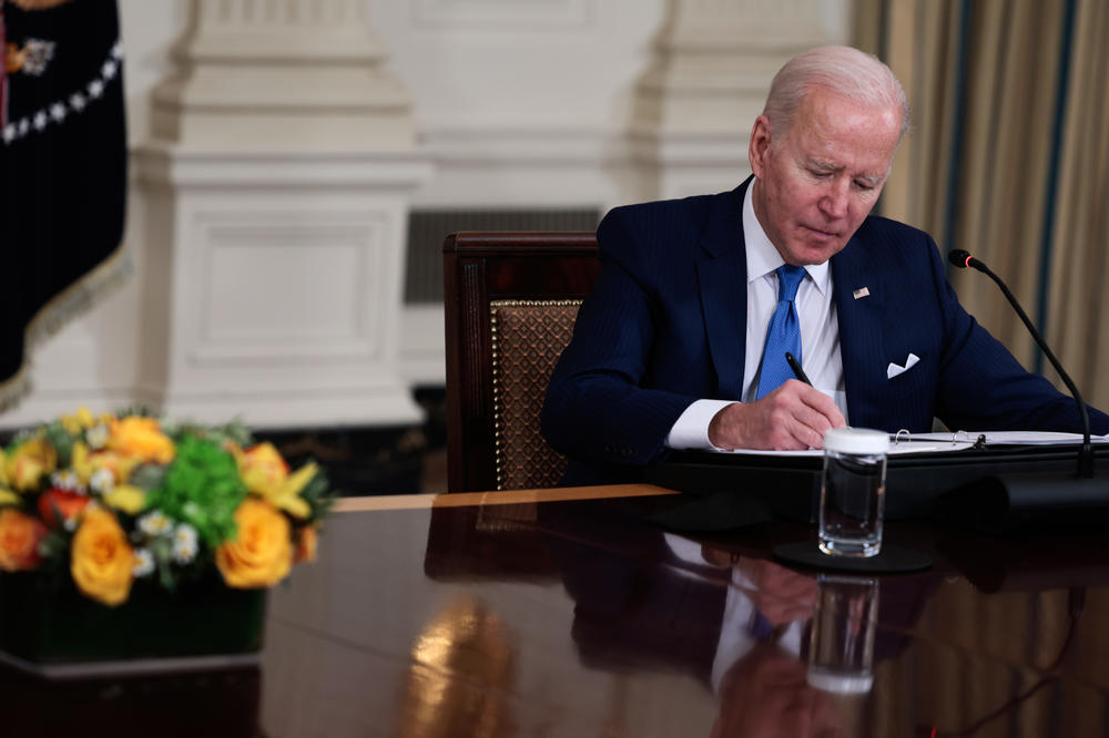 President Biden takes notes during a meeting to discuss clean energy efforts with CEOs of U.S. electric utility companies at the White House in February 2022.