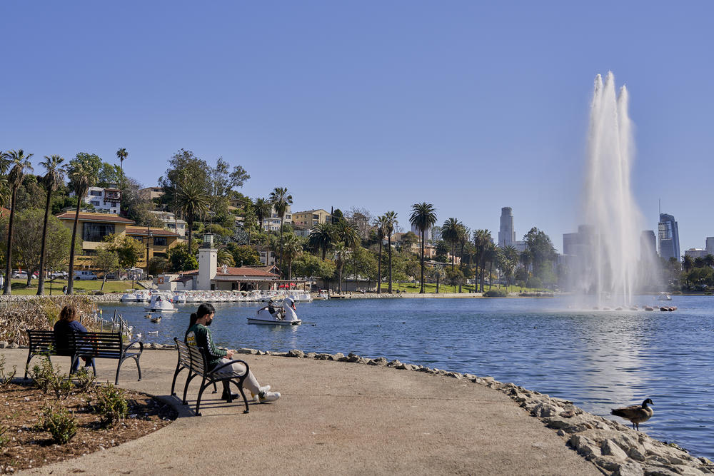 People sit on a bench at Echo Park Lake in March.