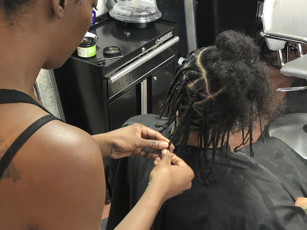 Shana Bonner, left, styles the hair of Pho Gibson at Exquisite U hair salon in this July 3, 2019, file photo. The U.S. House passed a federal anti-bias bill to protect against discrimination of race-based hairstyles.