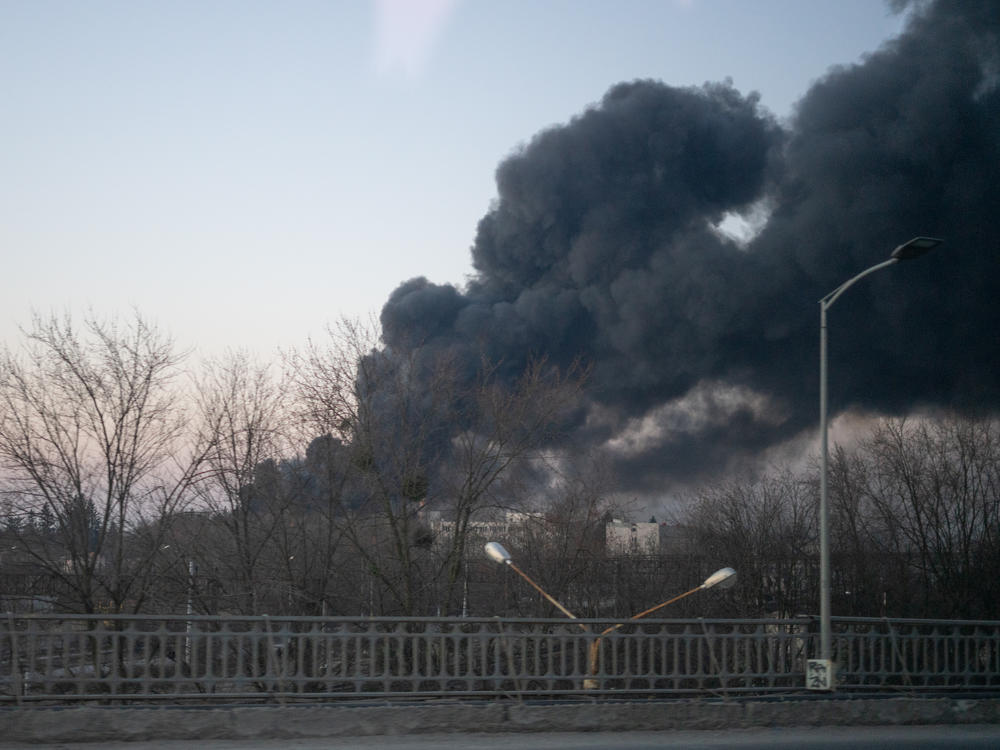 Smoke billows over a street near the airport in Lviv, Ukraine.