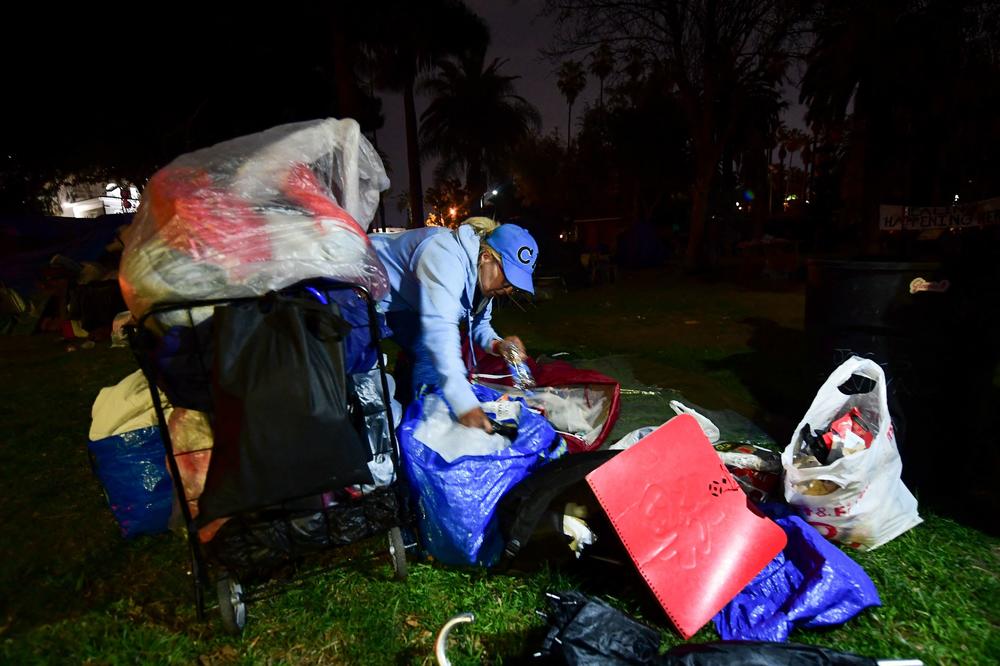 A woman packs her belongings on March 24, 2021, before police begin clearing out the encampment at Echo Park Lake.