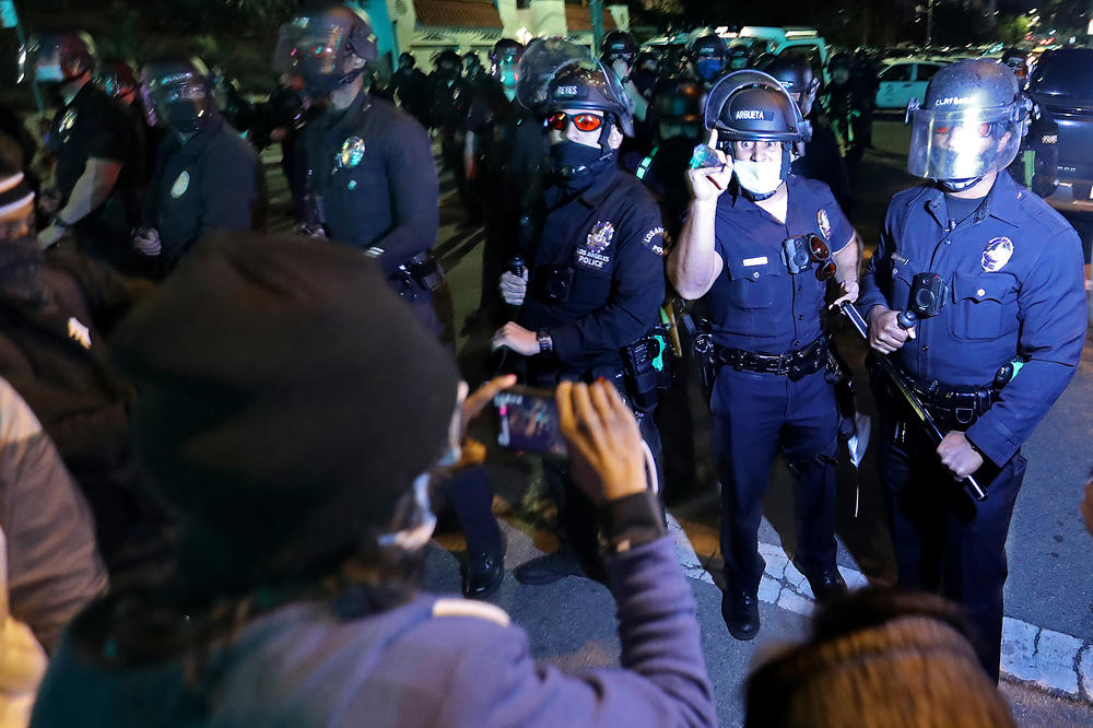 Protesters and police exchange words near a homeless encampment in Echo Park in Los Angeles on March 24, 2021.