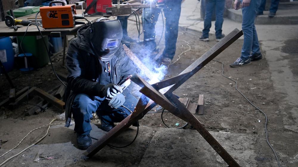 Volunteers connect I-beams to make anti-tank obstacles known as Czech hedgehogs, in a workshop in Lviv, western Ukraine, on March 3.