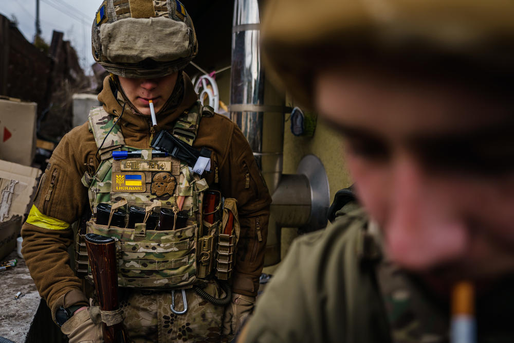 Ukrainian soldiers smoke as they defend themselves against Russian forces, in Irpin, Ukraine, Sunday, March 6, 2022.
