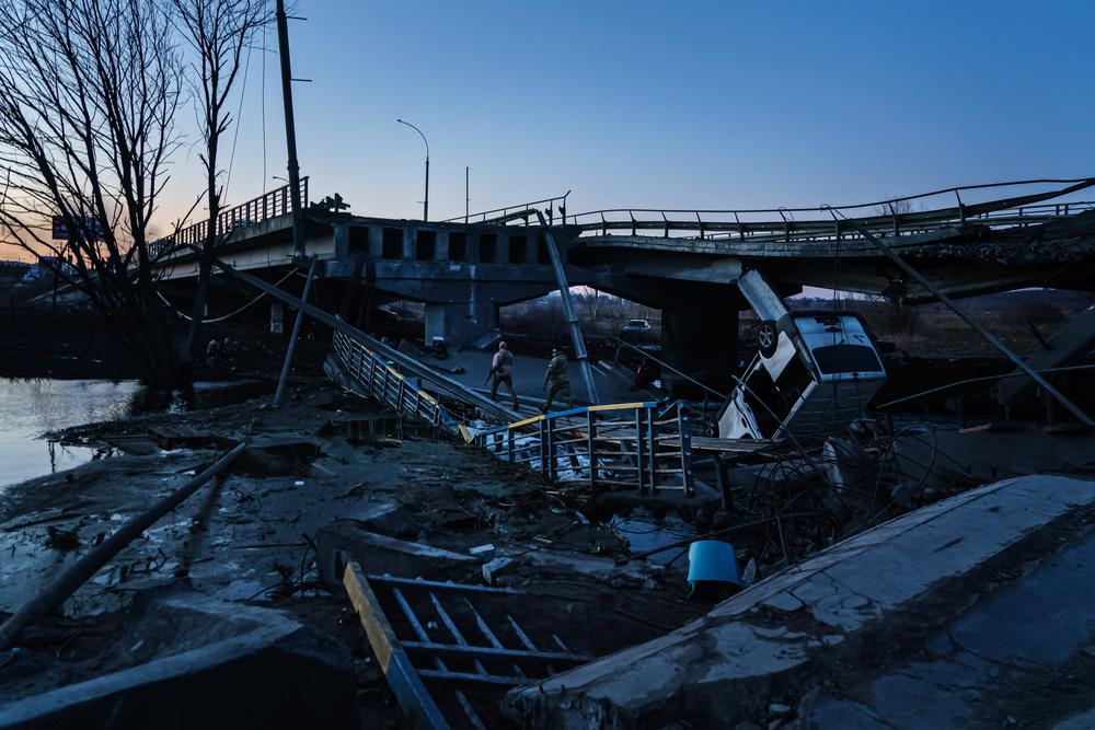 Ukrainian soldiers cross the Irpin river, after it was destroyed to prevent Russian tanks from crossing it, in Irpin, Ukraine, Thursday, March 10, 2022.