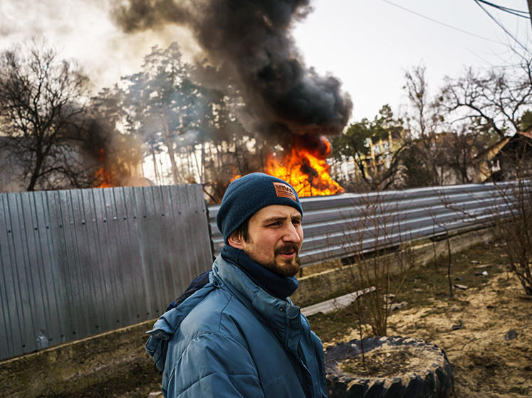 Maksim Chepchenko near a burning home in in Irpin, Ukraine, after Russian bombings on Saturday.