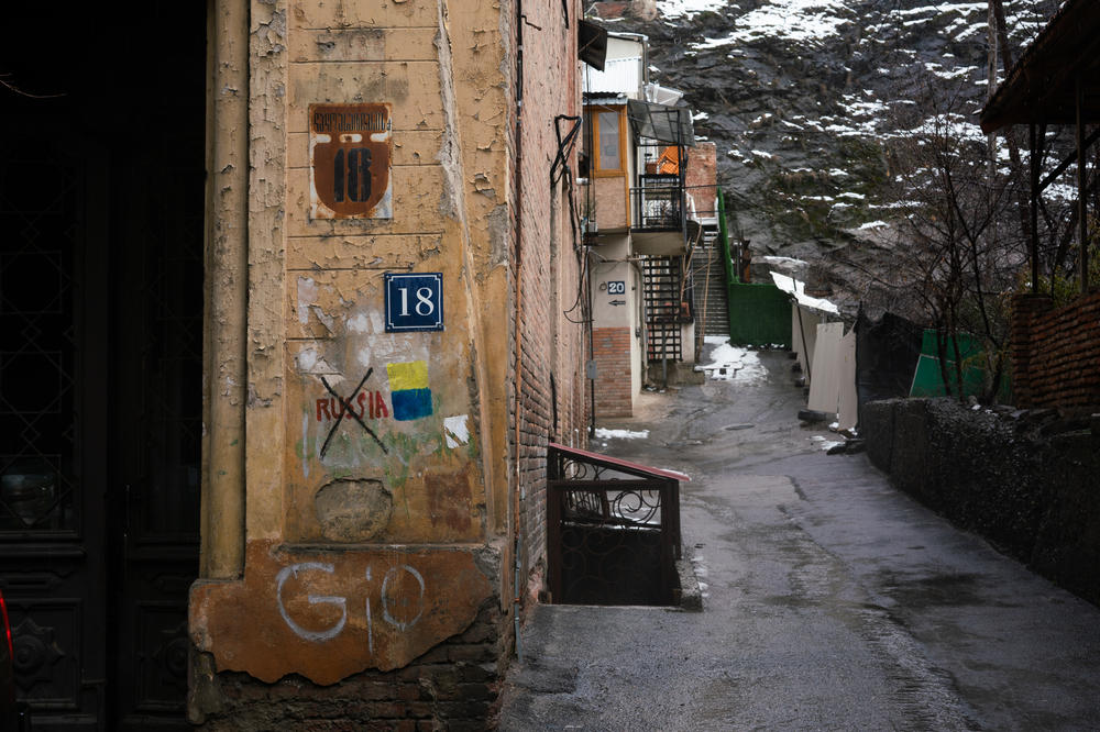 Graffiti on a street corner in downtown Tbilisi, Georgia, shows Russia crossed out and the flag of Ukraine next to it.