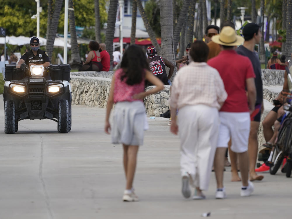 A police officer on an ATV patrols in Miami Beach, Fla.'s famed South Beach in March 2021. City of Miami Beach officials declared a state of emergency on Monday, and an upcoming curfew, bidding to curb violent incidents at spring break that saw five people wounded in two separate shootings.