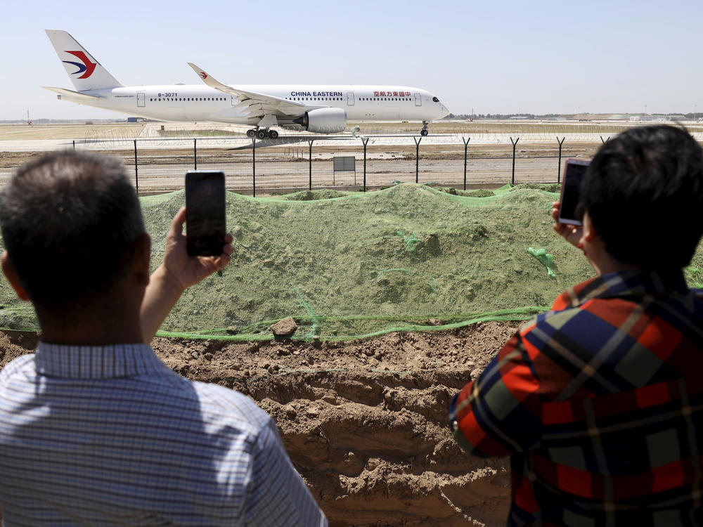 In May 2019, residents watch as a China Eastern passenger jet prepares to take off on a test flight from the new Beijing Daxing International Airport. State media are reporting a Chinese airliner from China Eastern with 132 people on board crashed in the southern province of Guangxi on Monday.