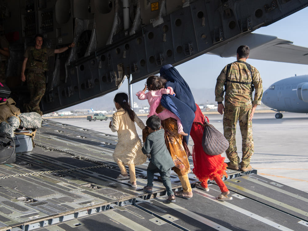 A family enters a U.S. Air Force plane in Kabul, Afghanistan, on Aug. 24, 2021. The evacuation was part of a U.S. effort to relocate Afghans to safety in the wake of the Taliban siege. But many families were separated in the process — and reuniting them has proven to be a challenge.