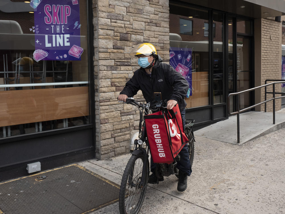 In this April 21, 2021, file photo, a delivery man bikes with a food bag from Grubhub in New York. The three biggest food delivery companies, DoorDash, Grubhub and Uber Eats, sued the City of New York in 2021 over its law to permanently limit the amount they can charge restaurants that use their services.