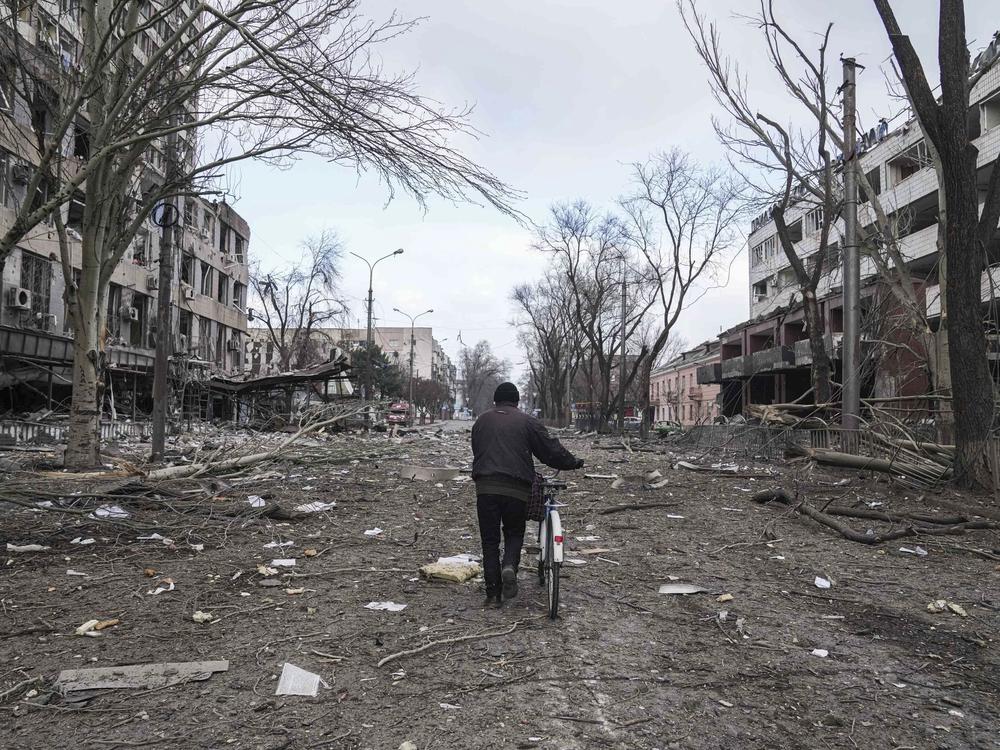 A man walks with a bicycle on a street damaged by shelling in Mariupol, Ukraine, earlier this month.