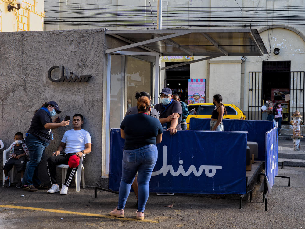 People get help on issues or setting up their digital wallet at a Chivo Wallet ATM post. The Salvadoran government offered residents $30 worth of bitcoin to use the new digital wallet, though some Salvadorans say they took the money out rather than use the bitcoins.
