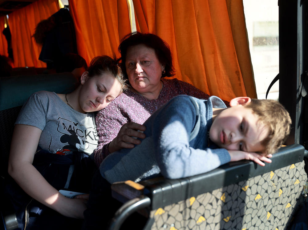 Sywasz Elizabeth, Samarska Ludmyla and Pylypenko Arsenij wait on a bus after arriving safely on a train in Lviv, Ukraine, from the Ukrainian city of Mariupol, which has been under heavy Russian military attack, on Tuesday. Trains carried hundreds of evacuees from the besieged city, where thousands of residents remain trapped amid Russian bombardment.