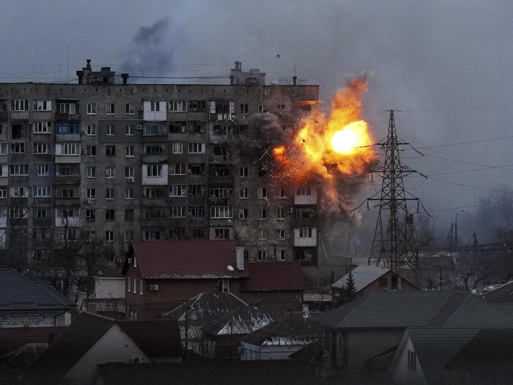 An explosion is seen on March 11 in a Mariupol apartment building after a Russian army tank fires.