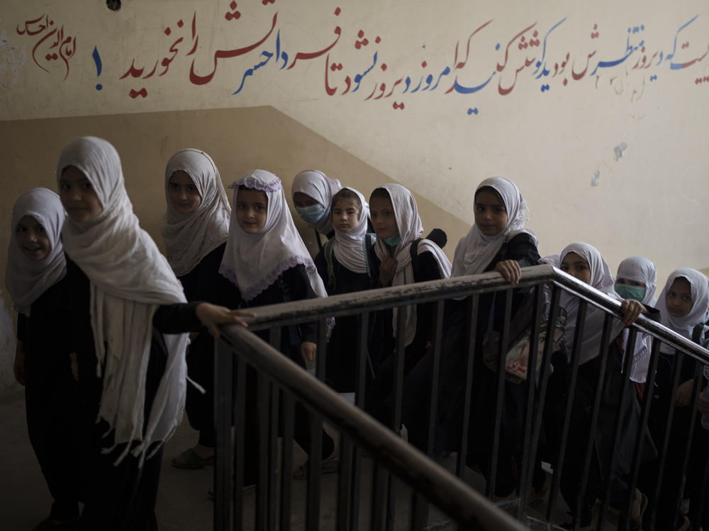Girls enter a school before class in Kabul on Sept. 12, 2021. In a surprise decision, the hardline leadership of Afghanistan's new rulers has decided against opening educational institutions to girls beyond sixth grade.