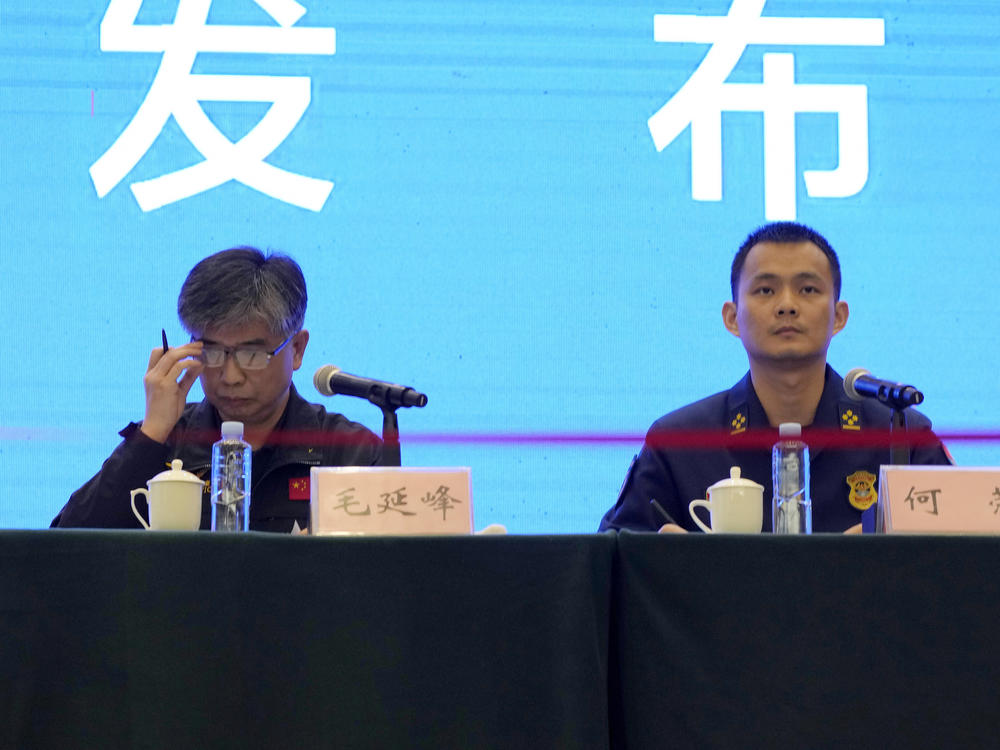 Mao Yanfeng, the director of the accident investigation division of the Civil Aviation Authority of China (left), and He Rong from the Guangxi Fire and Rescue Force attend a press conference in Wuzhou city on Wednesday in southwestern China's Guangxi province. China says one of two so-called black boxes from Monday's plane crash was found in severely damaged condition.