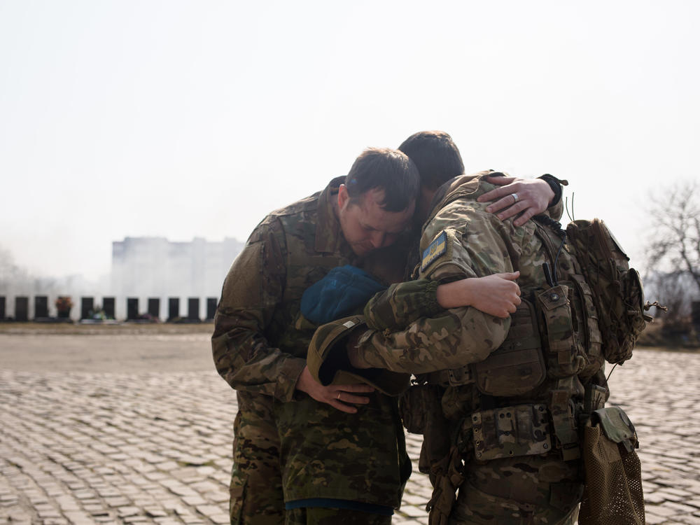 Ukrainian servicemen comfort Daniil, 12, the son of Vladyslav Buvalkin, 42, who died in action and was buried on Wednesday in Kyiv, Ukraine. Ukrainian forces have managed to fend off Russian advances near the capital, although shellfire and aerial bombardment persist.