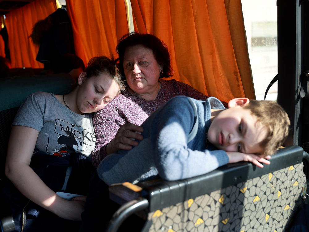 Passengers from Mariupol wait on a bus on Tuesday after arriving safely on a train to Lviv, Ukraine.