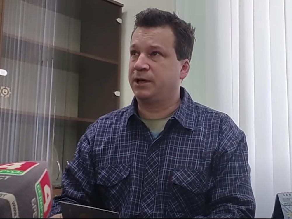 Evan Neumann, who is wanted by the FBI, holds his new Belarusian documents at the department of citizenship and migration office in Brest, Belarus.