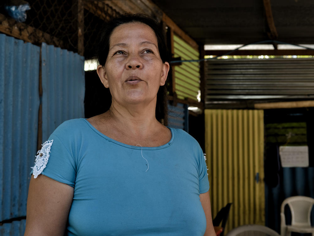 María del Carmen Aguirre talks about the advantages of using bitcoin and a digital wallet for her business, a convenience store which has her name, in El Zonte beach town.