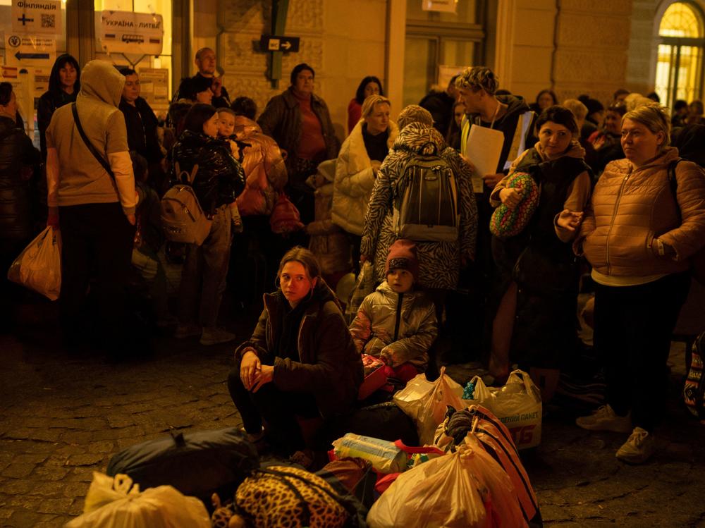 Refugees from Ukraine wait to get on buses to other destinations in Poland, outside the train station in Przemysl, near the Ukrainian-Polish border in southeastern Poland, on Wednesday.
