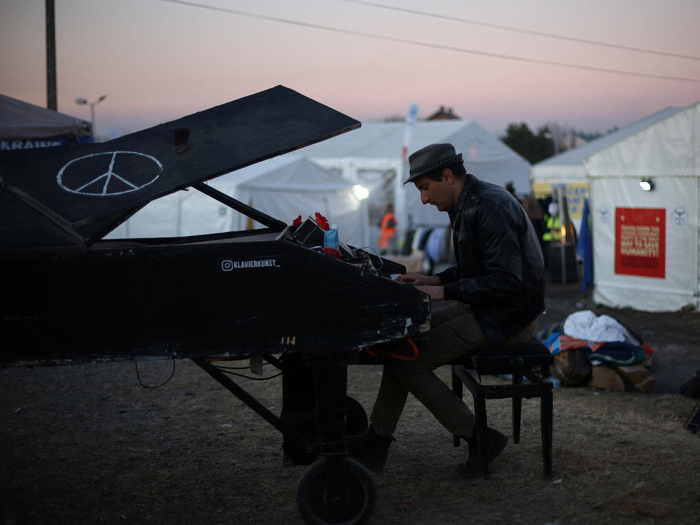 Davide Martello, an Italian man living in Germany, plays the piano for people who have fled Ukraine at the border crossing in Medyka, Poland.