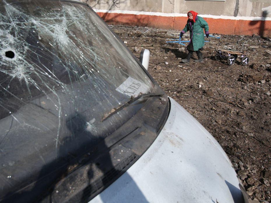 An elderly woman walks with a cart March 14 in a residential area damaged in what is said was an explosion of a ballistic missile in Kramatorsk, Ukraine, in the northern part of the Donetsk oblast.