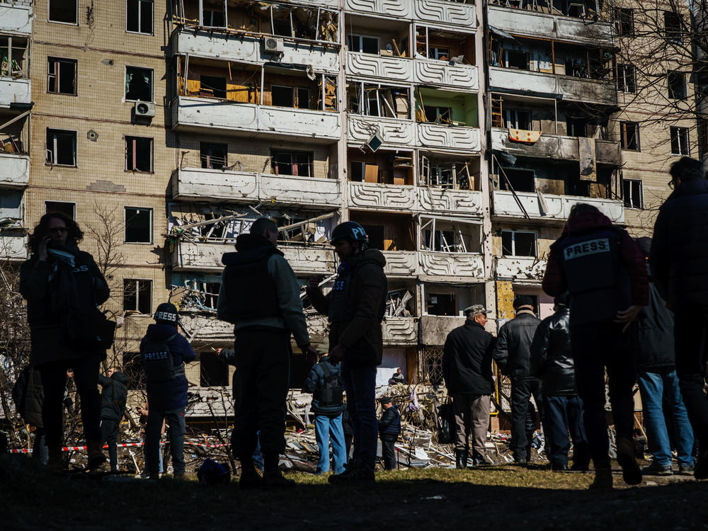 Reporters and residents stand outside a residential building that was damaged by what authorities say is a Russian bombardment in the Vynogradir district of Kyiv, Ukraine on  March 15. Some Ukrainian journalists have been detained and held hostage in Russian-occupied areas of the country.