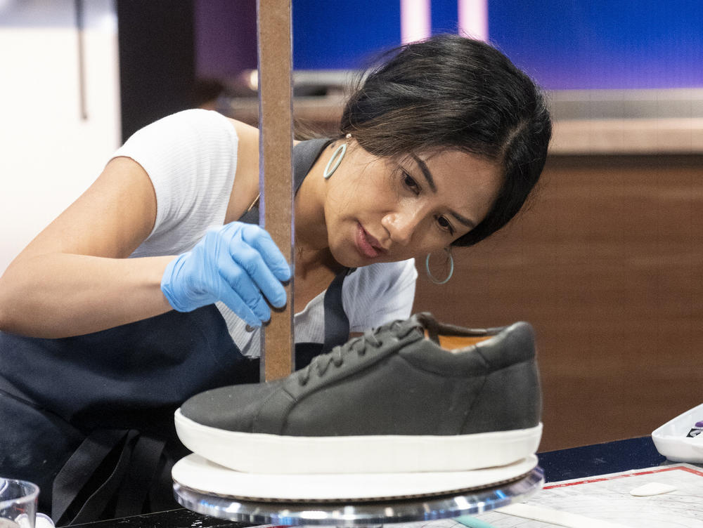April Julian on <em>Is it Cake?, </em>measuring a cake made in the image of a shoe.