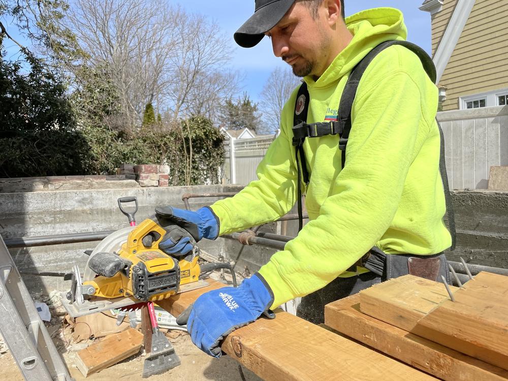 Hipolito Herrador is fashioning supports to hold up a portion of an existing house so an additional apartment unit can be built onto it. Some states and towns are changing their zoning rules to make it easier to add such 