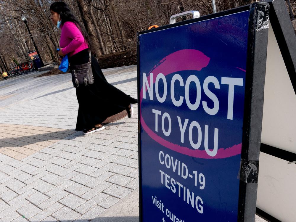 A person walks past a COVID-19 testing location in Arlington, Va., on March 16. A new website launched by the Biden administration will provide a locater for test-and-treat facilities, among other services.