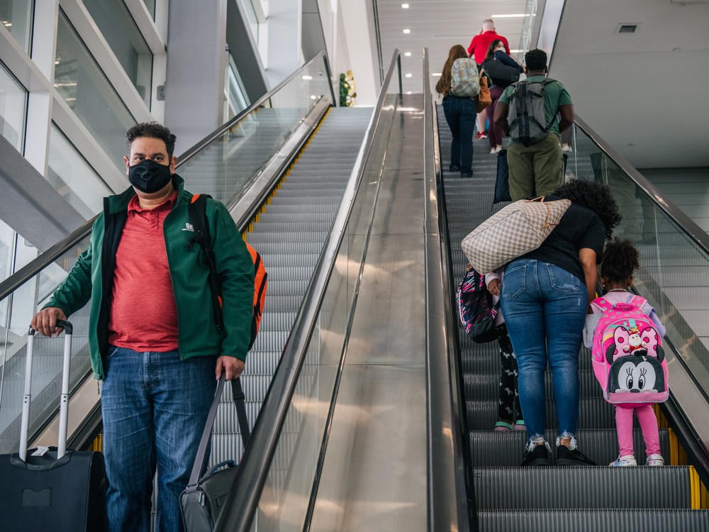 People travel through the George Bush Intercontinental Airport in Houston. Governors from 21 states are suing to end the federal mask mandate for public transportation.