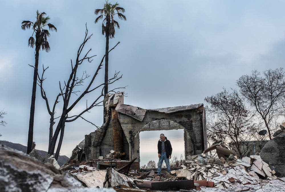 Mike stands in what used to be the doorway of his and his wife Cathy's home, which was destroyed by California's Woosley fire, in December 2018.