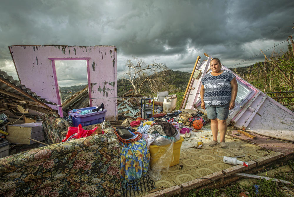 After Hurricane Maria ravaged Puerto Rico on Sept. 20, 2017, Glenda Bonilla, 27, tries to hold back tears as she surveys the damage to her home, where she — as well as her two daughters — were born, in Maricao.