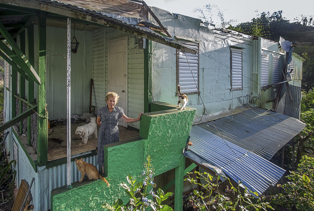 Yolanda Picó, 75, stands with her pets on what used to be the porch of her home of the last 40 years — destroyed by Hurricane Maria on the morning of Sept. 20, 2017, in Maricao, Puerto Rico.