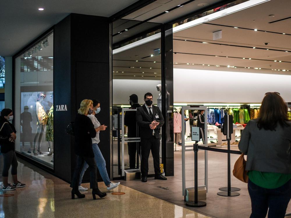 Customers queue to enter a re-opened Zara clothes shop at Colombo shopping center in Lisbon, Portugal, on in April 2021.